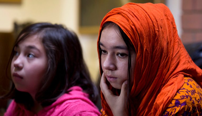 In this Nov. 29, 2018 photo, Shahnaz, 16, right, and Shakeela, 12, daughters of Mir Aman, speak to The Associated Press, in Islamabad, Pakistan. Scores of Pakistani men like Aman, whose Muslim Uighur wives have disappeared into internment camps in China, feel helpless, fighting a wall of silence as they struggle to reunite their families.