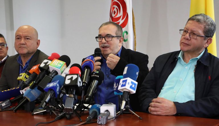 Carlos Lozada, left, and Pablo Catatumbo, right, Rodrigo Londono who had been the FARC top military commander, now heads its legal political party, speaks during a press conference in Bogota, Colombia, Thursday, Aug. 29, 2019. 