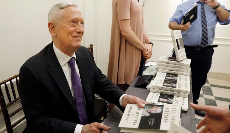 Former U.S. Secretary of Defense Jim Mattis signs copies of his book.