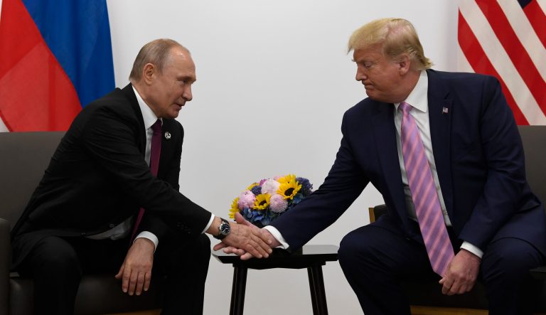 President Donald Trump, right, shakes hands with Russian President Vladimir Putin 