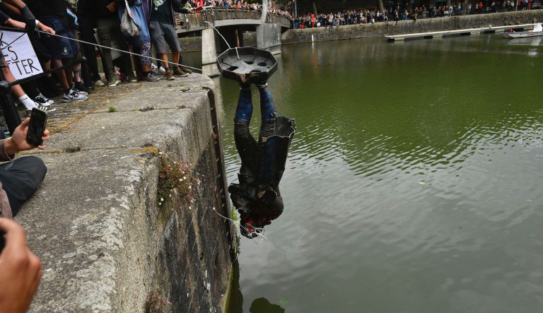 British protesters tear down statue of slave trader and throw it into water