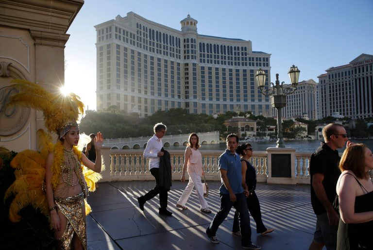 In this Friday, Aug. 15, 2014 photo, people walk by the Bellagio, in Las Vegas. This year, hotels will take in a record $2.25 billion in revenue from fees and surcharges, 6 percent more than in 2013 and nearly double that of a decade ago, according to a new study. Nearly half of the increase can be attributed to new surcharges and hotels increasing the amounts of existing fees. (AP Photo/John Locher)