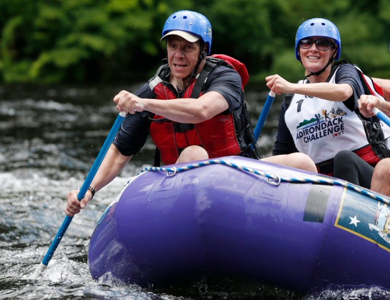 New York Gov. Andrew Cuomo, left, and his girlfriend Sandra Lee paddle with teammates during a rafting competition during the Adirondack Challenge on the Indian River on Sunday, July 20, 2014, in Indian Lake, N.Y. Cuomo and Vermont Gov. Peter Shumlin are squaring off in the rafting race meant to highlight the Adirondacks' recreational opportunities. (AP Photo/Mike Groll)