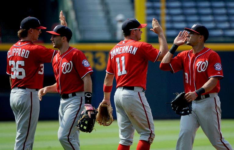 Washington Nationals pitcher Tyler Clippard (36) and third baseman Ryan Zimmerman (11) celebrate their 8-4 win over the Atlanta Braves with Bryce Harper and Ian Desmond, right, after their baseball game, Sunday, July 1, 2012, at Turner Field in Atlanta. (AP Photo/David Tulis)