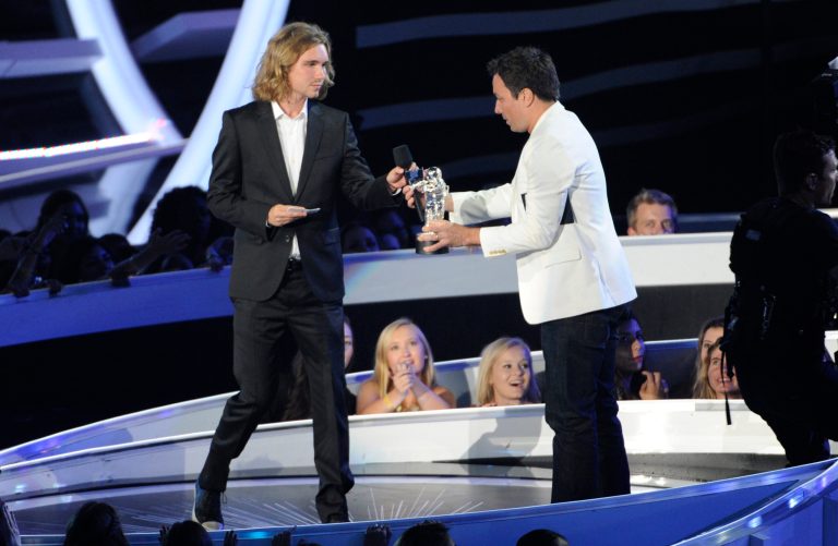 FILE - In this Aug. 24, 2014 file photo, Jesse Helt, a homeless man, left, accepts the award for Video of the Year from Jimmy Fallon on behalf of Miley Cyrus on stage at the MTV Video Music Awards in Inglewood, Calif. Helt arrived 45 minutes late for his arraignment Tuesday, Sept. 16, on a charge that he violated his probation in Oregon. He gained worldwide attention last month when Cyrus let him accept her award for video of the year. It was later learned that Helt was wanted in Oregon for a probation violation stemming from a 2010 arrest. (Photo by Chris Pizzello/Invision/AP, File)