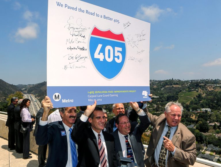 Los Angeles city officials hold an Interstate 405 banner after announcing the car pool lane opening, higher-capacity on- and off-ramps and bridges that meet seismic standards at the Getty Center in Los Angeles Friday, May. 23, 2014. Los Angeles city officials from left, are, City Attorney Mike Feurer, Mayor Eric Garcetti, council members, Paul Koretz, and Tom LaBonge.  (AP Photo/Damian Dovarganes)