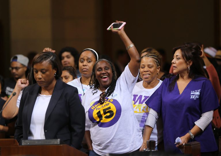 Laphonza Butler, President of SEIU ULTCW, the United Long Term Care Workers' Union, far left, joins workers demanding the Los Angeles City Council to vote to raise the minimum wage Tuesday, May 19, 2015, in Los Angeles. The city council gave initial approval Tuesday to raising minimum pay in the nation's second-largest city to $15 an hour by 2020. (AP Photo/Damian Dovarganes )