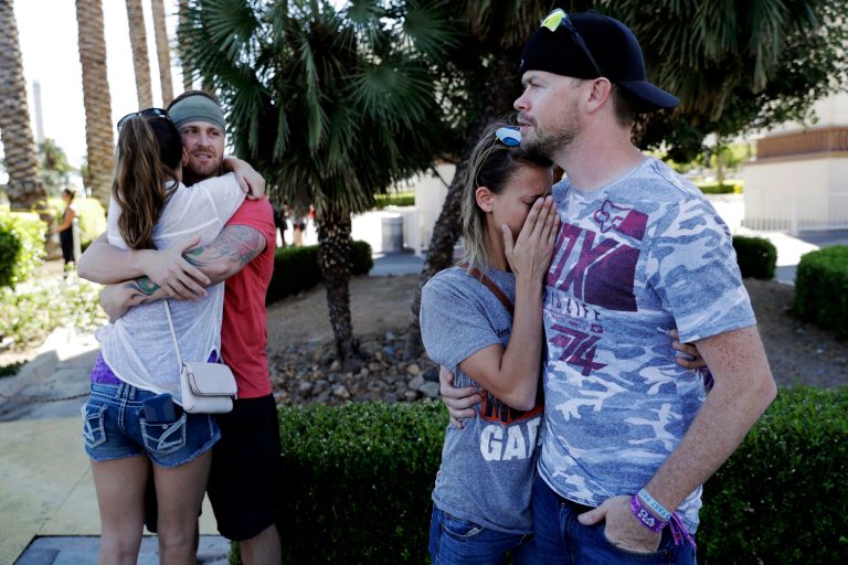 Sean Bean, of Livermore, Calif., hugs his girlfriend Katie Kavetski, of San Leandro, Calif., left, as Travis Reed, of Mexico, Ind., right, comforts his girlfriend Anna Travnicek, second from right, on Las Vegas Strip, Monday, Oct. 2, 2017, in Las Vegas. All attended a concert where a mass shooting occurred on Sunday. (AP Photo/Marcio Jose Sanchez)