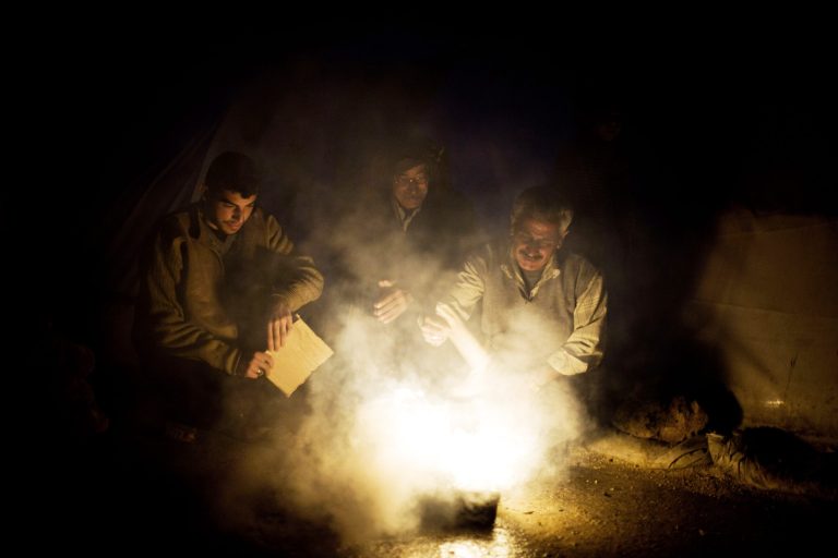   Syrian men heat a fire to boil water near their tent at a refugee camp near the Turkish border, in Azaz, Syria, Sunday, Dec. 9, 2012. (AP Photo/Manu Brabo)  