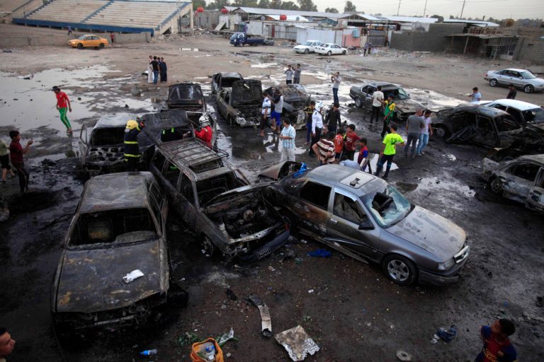 Iraqis gather at the scene of a car bomb attack at a used cars dealers parking lot in Habibiya neighborhood of eastern Baghdad, Iraq, Monday, May 27, 2013. A wave of car bombings tore through mostly Shiite Muslim neighborhoods of the Baghdad area, killing and wounding dozens of people, police said, in the latest outburst of an unusually intense wave of bloodshed roiling Iraq. The blasts are the latest indication that Iraq's security is rapidly deteriorating. (AP Photo/ Karim Kadim)