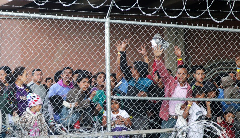 In this March 27, 2019, file photo, Central American migrants wait for food in a pen erected by U.S. Customs and Border Protection to process a surge of migrant families and unaccompanied minors in El Paso, Texas.