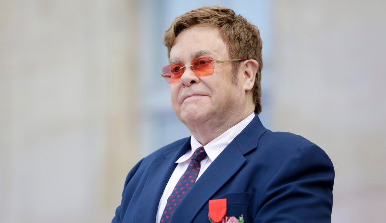 Sir Elton John listens in courtyard of the presidential Elysee Palace in Paris, Friday, June 21, 2019. Sir Elton John received the Legion of Honor, seen on his jacket, France's highest award, during a visit to the presidential Elysee Palace.