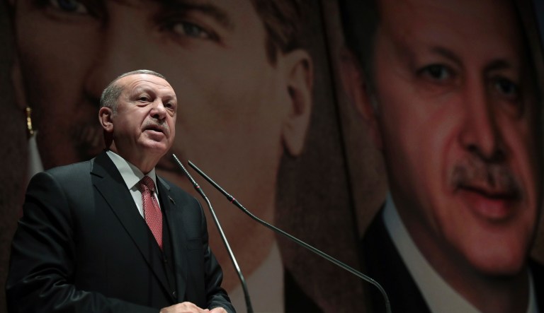 Backdropped by a picture of modern Turkey's founder Mustafa Kemal Ataturk, back left, Turkey's President Recep Tayyip Erdogan, with his image right, talk to his ruling Justice and Development Party (AKP) provincial leadership members in Ankara, Turkey, Tuesday, Jan. 29, 2019. 