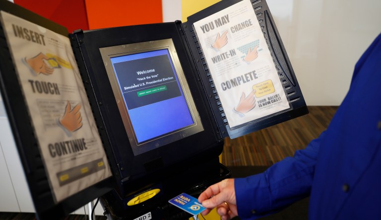 FILE - In this Wednesday, Sept. 28, 2016 file photo, Brian Varner, a principal researcher at Symantec, inserts an identifying chip card into an electronic voting machine as he demonstrates how to hack an electronic voting machine at a Symantec office in New York.