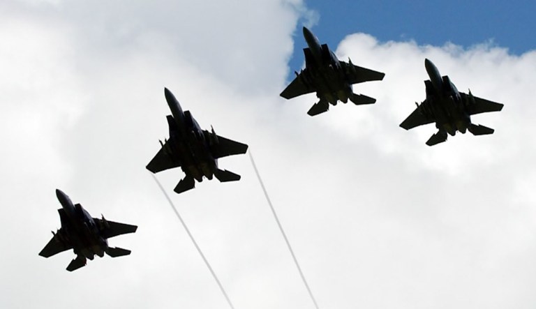 Several American F-15 planes in fly in formation.