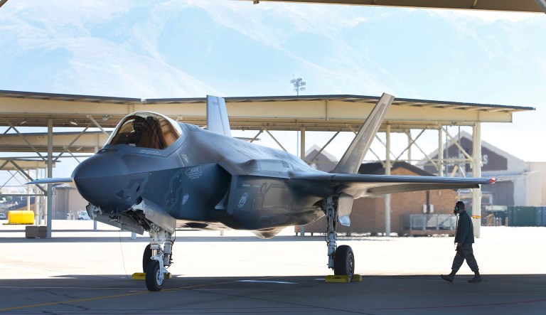 A fighter pilot sits in the cockpit while a crew member checks the exterior of a Lockheed Martin Corp. F-35A jet before a training flight in Hill Air Force Base, Utah, U.S., on Friday, Oct. 21, 2016. Lockheed Martin Corp.'s accelerating revenue growth outlook is boosted by its recent portfolio moves, which are enabling the world's largest defense contractor to better capitalize on higher foreign demand. Rising F-35 production is a key driver, as deliveries are to double by 2019 vs. current levels.