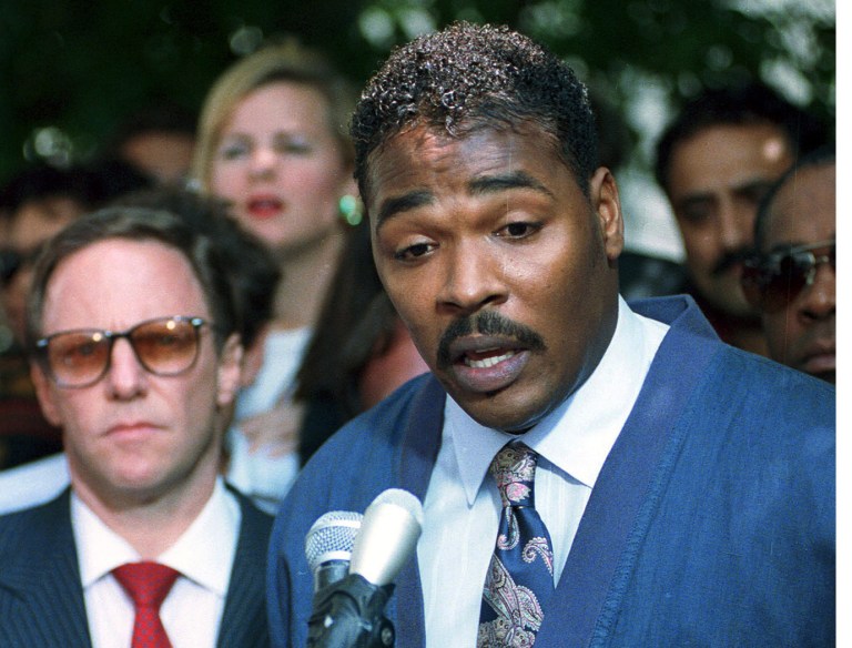 FILE - This May 1,1992 file photo shows Rodney King, right, accompanied by his attorney Steven Lerman, making his first statement, pleading for an end to the rioting in South Central Los Angeles, in Los Angeles. The St. Louis suburb of Ferguson, Missouri, was roiled by racial unrest after 18-year-old Michael Brown, who was black, was shot and killed by Darren Wilson, a white police officer, on Aug. 9. The street clashes there mirrored past, larger-scale riots in multiple US cities, most of them triggered by perceived racial injustice, or an incident involving police, in already tense communities.   (AP Photo/David Longstreath, File)