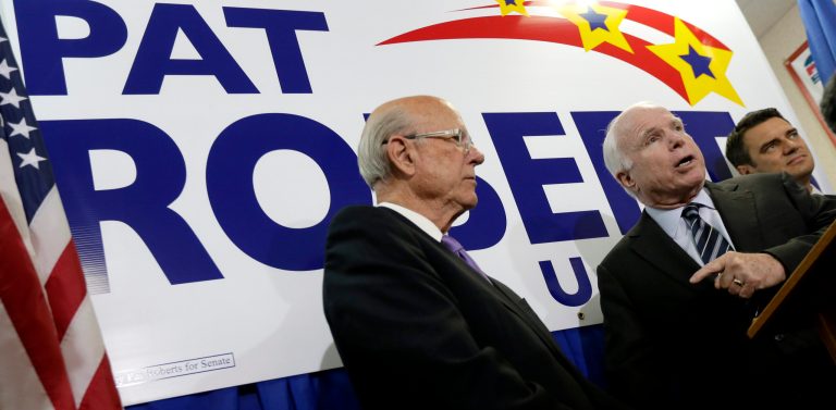 Republican Sen. Pat Roberts, left, listens while Sen. John McCain, R-Ariz., talks to supporters at a campaign stop at Johnson County Republican headquarters Wednesday in Overland Park, Kan. (AP/Charlie Riedel)