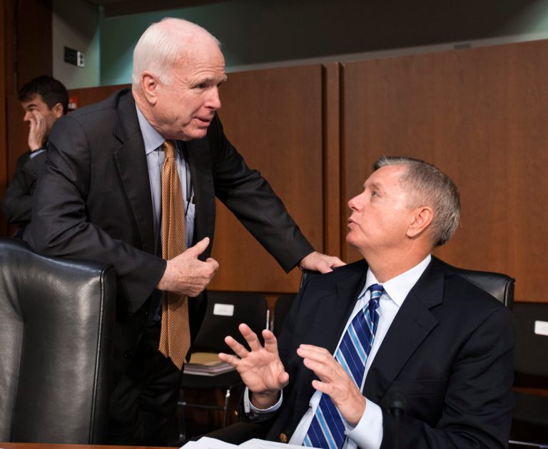 Sen. John McCain, R-Ariz., left, talks with Sen. Lindsey Graham, R-S.C., on Capitol Hill in Washington in this July 18, 2013 file photo. (AP Photo/J. Scott Applewhite, File)