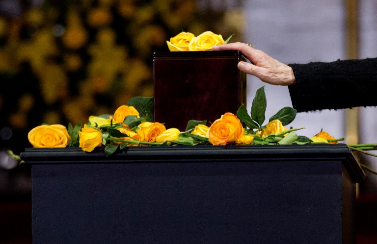 Silvia Lemus, widow of the Mexican author Carlos Fuentes, touches the urn containing Colombian Nobel Literature laureate Gabriel Garcia Marquez's ashes during an homage to the beloved author at the Palace of Fine Arts in Mexico City, Monday, April 21, 2014. The ashes of Garcia Marquez were taken Monday to Mexico City's majestic Palace of Fine Arts, where thousands of admiring readers began paying tribute to the Colombian Nobel laureate considered one of the greatest Spanish-language authors of all time. (AP Photo/Eduardo Verdugo)