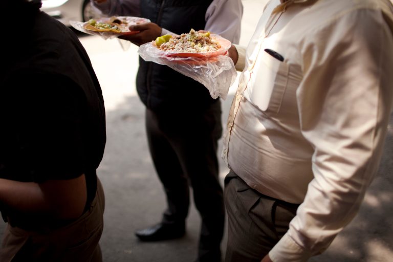 FILE - In this July 10, 2013, file photo, office workers eats tacos at an outdoor food stand during lunch time in Mexico City. Mexico has surpassed the United States in levels of adult obesity. Mexico's new food labeling rules were supposed to help fight an obesity epidemic, but activists and experts said Monday, april 21, 2014, that they may actually encourage the public to consume high levels of sugar. (AP Photo/Ivan Pierre Aguirre,File)