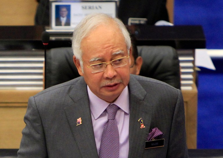 FILE - In this  July 23, 2014 file photo, Malaysian Prime Minister Najib Razak tables an emergency motion to condemn the suspected shooting of the Malaysia Airlines Flight 17 in eastern Ukraine, at the Parliament house in Kuala Lumpur, Malaysia. Malaysia said Sunday, July 27, 2014 that it would send dozens of police to the Malaysian airliner's crash site in eastern Ukraine after pro-Russia separatists agreed to allow international police personnel to provide protection for investigators. (AP Photo/Lai Seng Sin, File)