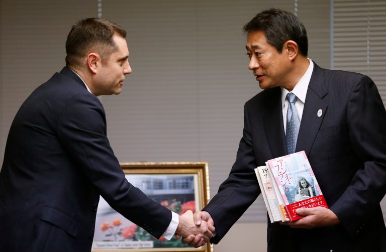 Israeli Embassy to Japan representative Peleg Lewi, left, shakes hands with Suginami Ward Mayor Ryo Tanaka as he hands over Anne Frank-related books to public libraries at the Suginami Ward Office in Tokyo Thursday, Feb. 27, 2014. The Israeli Embassy is donating 300 books after the recent vandalism of a similar number of such books in their collections. More than 300 books related to Anne Frank, including copies of 