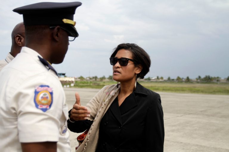 Cheryl Mills, chief of staff to Secretary of State Hillary Clinton, right, speaks to a police officer as she leaves after visiting the Caracol Haiti Industrial Park at an airport in Cap Hatien, Haiti, Wednesday, April 11, 2012. (AP Photo/Dieu Nalio Chery)
