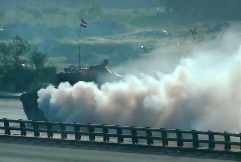 In this image taken from video obtained from the Shaam News Network, which has been authenticated based on its contents and other AP reporting, a Syrian military tank shells a neighborhood in Damascus, Syria, Thursday, March 28, 2013. (AP Photo/Shaam News Network via AP video)