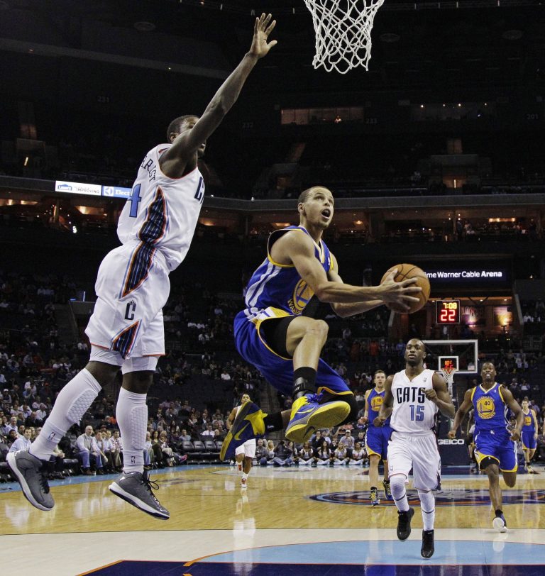   Golden State Warriors' Stephen Curry, center, drives past Charlotte Bobcats' Michael Kidd-Gilchrist, left, and Kemba Walker, back, during the first half of an NBA basketball game in Charlotte, N.C., Monday, Dec. 10, 2012. (AP Photo/Chuck Burton)  