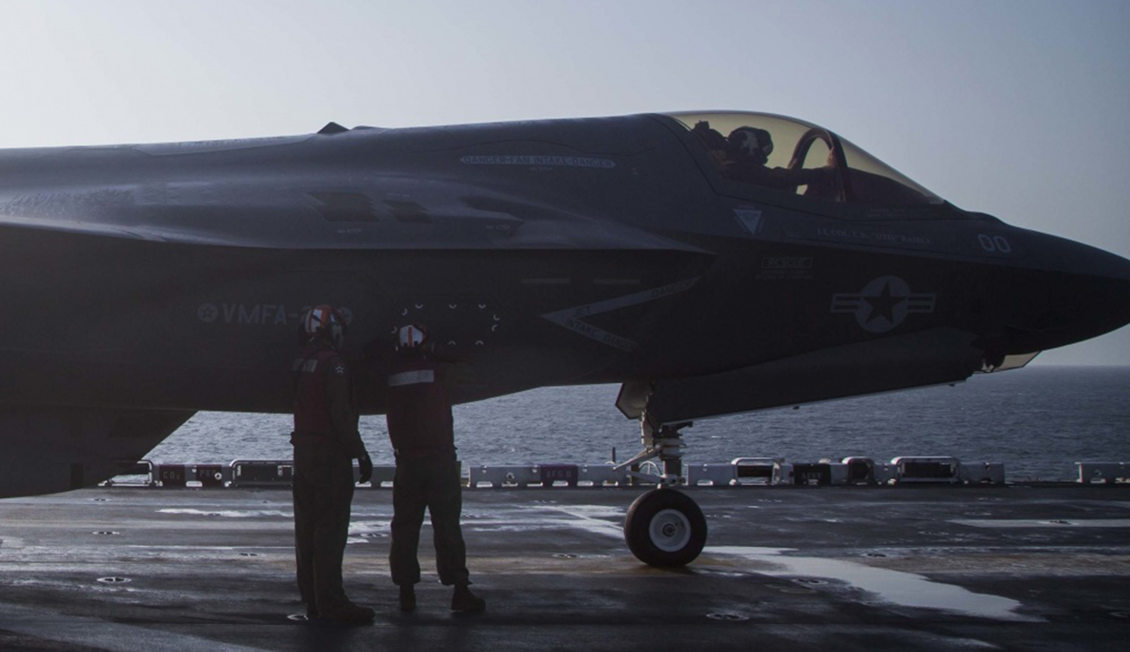U.S. Marines with Marine Fighter Attack Squadron 211, 13th Marine Expeditionary Unit, ensure a panel is secure on an F-35B Lightning II in preparation for the F-35B's first combat strike on Thursday.