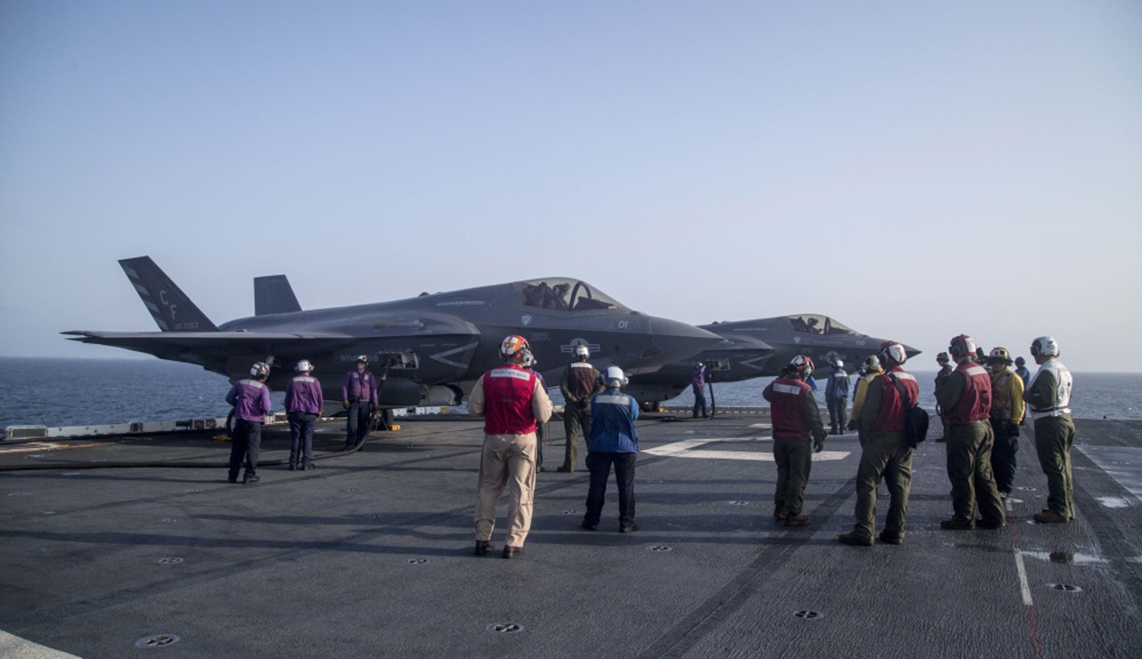 U.S. Marines and Sailors with the Essex Amphibious Ready Group and the 13th Marine Expeditionary Unit wait for flight operations to begin while F-35B Lightning IIs with Marine Fighter Attack Squadron 211, 13th MEU, are refueled in preparation for the F-35B's first combat strike on Thursday.