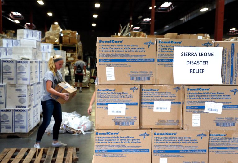 FILE - In this Sept. 9, 2014 file photo, Valor Christian High School sophomore and volunteer Paige Kula loads a pallet with medical supplies bound for Sierra Leone to combat Ebola, inside the warehouse of Project C.U.R.E., in Centennial, Colo. The US strategy in fighting Ebola is two-pronged: Step up efforts to deliver desperately needed supplies and people to West Africa, while making sure hospitals at home know what to do if someone travels here with the infection. In addition to shipments of hospital beds and protective suits, the government is taking unusual steps to encourage a variety of health care workers to volunteer to go to the outbreak zone _ and is offering some training before they head out. Here are questions and answers on the U.S. response. (AP Photo/Brennan Linsley, File)