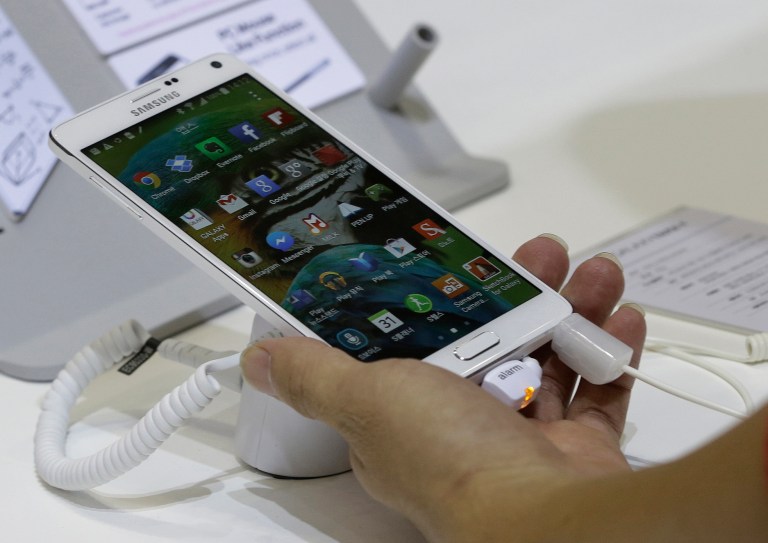 A visitor tries out a Samsung Electronics Co.'s Galaxy Note 4 smartphone during the 2014 Korea Electronics Show in Goyang, South Korea, Tuesday, Oct. 14, 2014. Sharper resolution, better cameras and battery life give the Note 4 a stronger edge than the phone's previous incarnation. However, just like the 5.5-inch iPhone 6 Plus, the 5.7-inch Note 4 will be too big for a lot of customers, unless you want to watch lots of video but not carry around a large tablet. (AP Photo/Ahn Young-joon)
