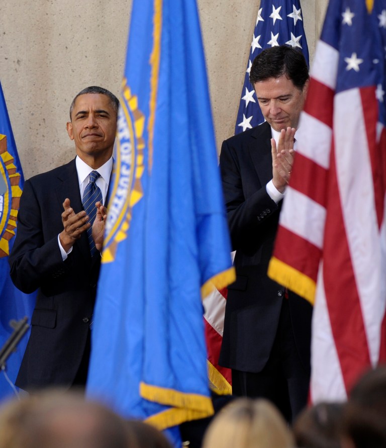 President Barack Obama stands with James Comey during the presentation of colors at Comey's installation as FBI Director, Monday, Oct. 28, 2013, at FBI Headquarters in Washington. Comey, a former Bush administration official who defiantly refused to go along with White House demands on warrantless wiretapping nearly a decade ago, took over last month for Robert Mueller, who stepped down after 12 years as agency director. (AP Photo/Susan Walsh)