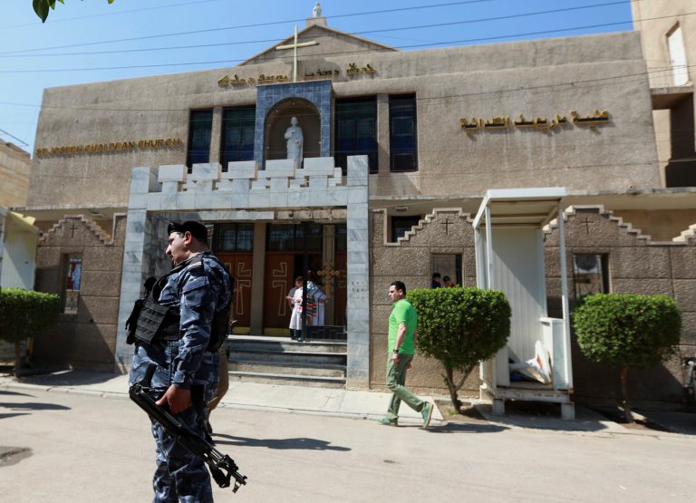 Iraqi security forces stand guard as Christians prepare to attend Easter at Mar Youssif Chaldean Church in Baghdad Sunday, April 16, 2017. The Chaldean Church is an Eastern Rite church affiliated with the Roman Catholic Church. (AP Photo/Hadi Mizban)