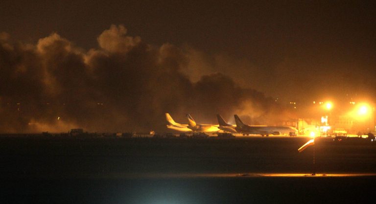 Fire illuminates the sky above Karachi airport terminal where security forces are fighting with attackers Sunday night, June 8, 2014, in Pakistan. Gunmen disguised as police guards attacked the terminal with machine guns and a rocket launcher during a five-hour siege that killed 13 people as explosions echoed into the night, while security forces retaliated and killed all the attackers, officials said Monday. (AP Photo/Fareed Khan)