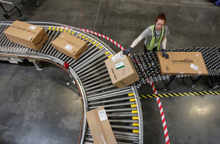 FILE - In this Nov. 11, 2010, file photo, Katherine Braun sorts packages toward the right shipping area at an Amazon.com fulfillment center in Goodyear, Ariz. Amazon is hiring 80,000 seasonal workers for its distribution centers as it looks to improve its shipping efficiency during the crucial 2014 holiday season. (AP Photo/Ross D. Franklin, File)
