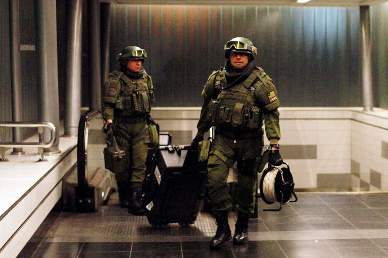 Police explosives experts, walk out of a subway station after a false alarm bomb alert in Santiago, Chile, Wednesday Sept. 10, 2014. President Michelle Bachelet boosted security at subway stations and elsewhere and has said she will use the country's tough, dictatorship-era terrorism laws, after Santiago was rattled by the series of low powered bombings. (AP Photo/ Luis Hidalgo)
