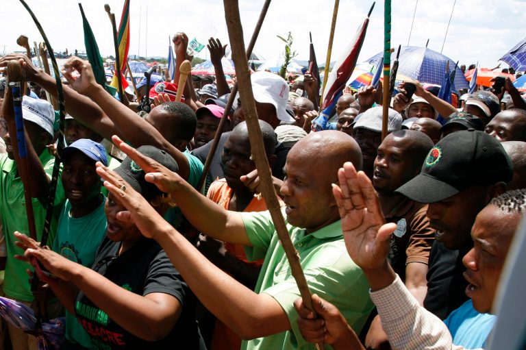 Union leader Joseph Mathunjwa, center, sings and dances with mine workers outside the Lonmin's platinum mine in Marikana near Rustenburg, South Africa, Thursday, Jan. 23, 2014. Allied Metal and Construction Workers Union (AMCU) at Lonmin in Marikana, Anglo American Platinum (Amplats) and Impala mines started a strike on Thursday pushing for an entry-level monthly salary of 12,500 rand (1147 US Dollars). (AP Photo/Themba Hadebe)