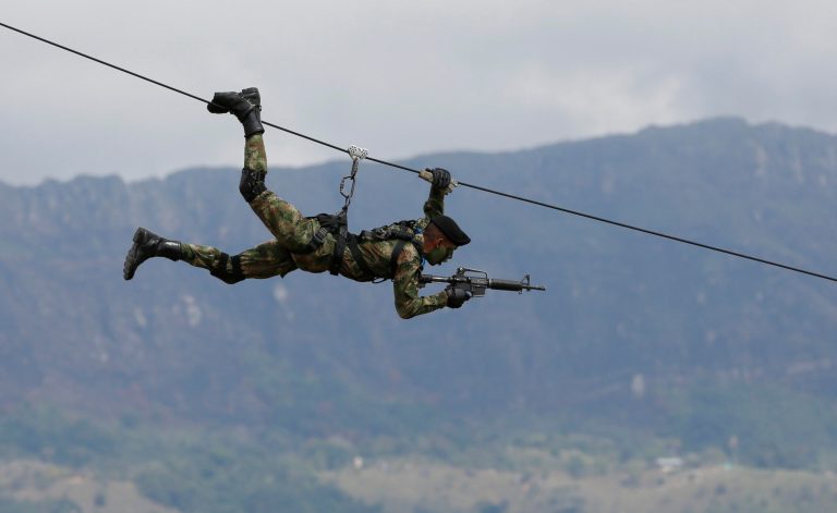 A Colombian Army Special Forces soldier ziplines during a show of military exercises at the Tolemaida military base during a visit by U.S. Defense Secretary Chuck Hagel, in Melgar, Colombia, Friday, Oct. 10, 2014. (AP Photo/Fernando Vergara)