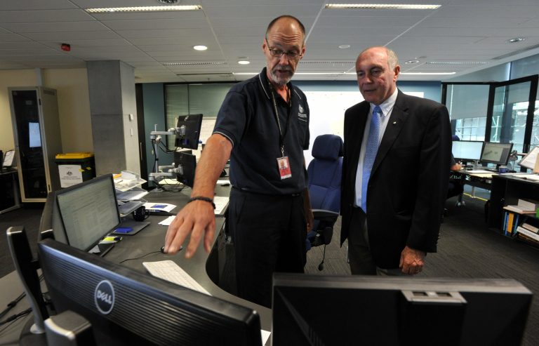 In this March 23, 2014 photo, Australian Deputy Prime Minister Warren Truss, right, talks with John Rice, senior search and rescue officer and mission coordinator for the search for the missing Malaysia Airlines Flight MH370, at rescue coordination center of the Australian Maritime Safety Authority in Canberra. Just weeks before the hunt for the missing Malaysian airliner is set to resume, an Australian official said Thursday, Aug. 28, that the sprawling search area in the southern Indian Ocean may be extended farther south based on a new analysis of a failed attempt to call the plane by satellite phone. Truss said the analysis of the call, attempted by Malaysia Airlines officials on the ground soon after Flight 370 disappeared from radar, 