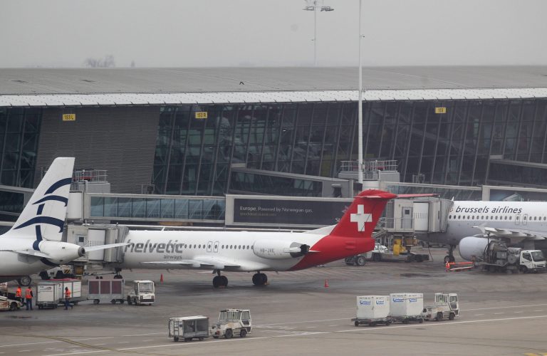 FILE - Baggage carts make their way past a Helvetic Airways aircraft from which millions' of dollars worth of diamonds were stolen on the tarmac of Brussels international airport, in this Feb. 19, 2013 file photo. Police on Wednesday May 8, 2013 claimed a major breakthrough in their investigation of a spectacular $50 million diamond heist, detaining 31 people in a three-nation sweep some three months after robbers pulled off the theft with clockwork precision at Brussels Airport. (AP Photo/Yves Logghe, File)