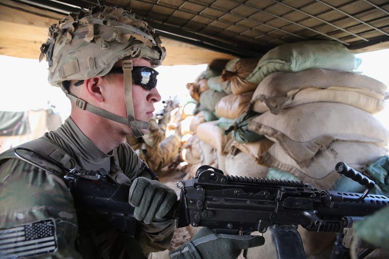 Pfc. Michael Covich from Auburn, N.Y., with the Army's 2nd Battalion 87th Infantry Regiment, 3rd Brigade Combat Team, 10th Mountain Division keeps watch from inside an Afghan National Army outpost during a patrol outside of Forward Operating Base Shank on March 29, 2014 near Pul-e Alam, Afghanistan. (Photo by Scott Olson/Getty Images)