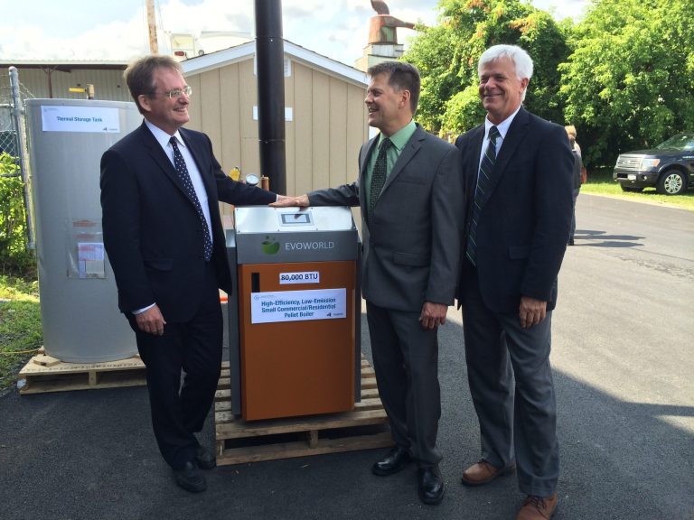 John Rhodes, left, president of the New York State Energy Research and Development Authority, stands beside a wood-pellet heating system along with Lou Okonski, center, CEO of the Evoworld heating system company, and Joe Martens, commissioner of the New York State Department of Environmental Conservation, on Tuesday, July 29, 2014 in Troy, N.Y.  Gov. Andrew Cuomo has launched a $27 million initiative to build the market for high-efficiency wood heating systems in New York. The program is aimed at developing more clean technology manufacturing in the state along with a skilled heating system installer base and sustainably harvested wood fuels from state forests.  (AP Photo/Mary Esch)
