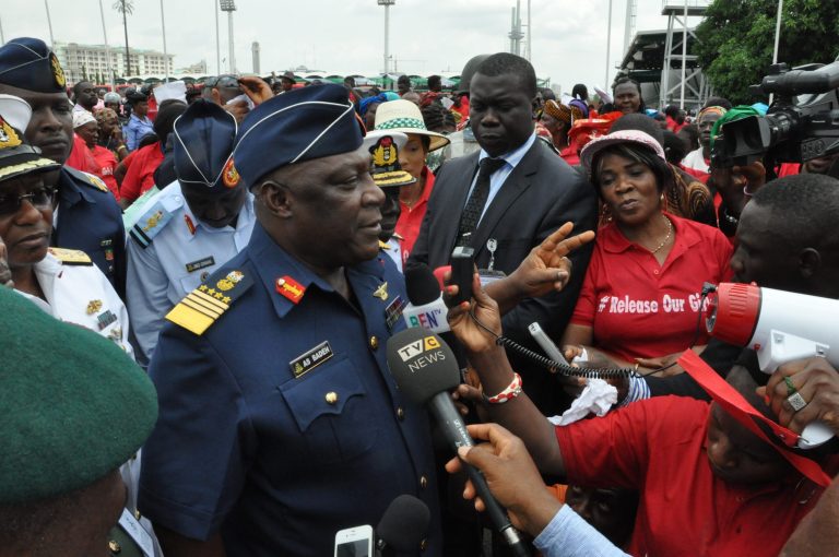 Nigeria's chief of defense staff Air Marshal Alex S. Badeh, centre, speaks during a demonstration calling on the government to rescue the kidnapped girls of the government secondary school in Chibok, in Abuja, Nigeria, Monday, May 26, 2014. Scores of protesters chanting 