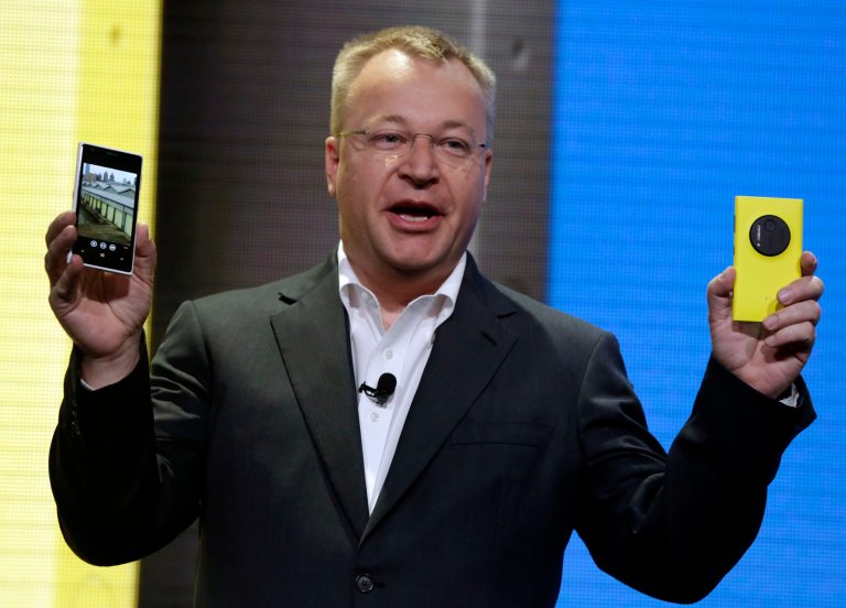 FILE - In this July 11, 2013 file photo, then Nokia CEO Stephen Elop shows the company's Nokia Lumia 1020, in New York. Elop, now Microsoft Executive Vice President, sent employees of the company's devices business a memo detailing its job cut plans. Microsoft on Thursday, July 17, 2014 said it would cut up to 18,000 jobs over the next year, with about 12,500 related to Microsoft's acquisition of Nokia's phone business in April. (AP Photo/Richard Drew, File)