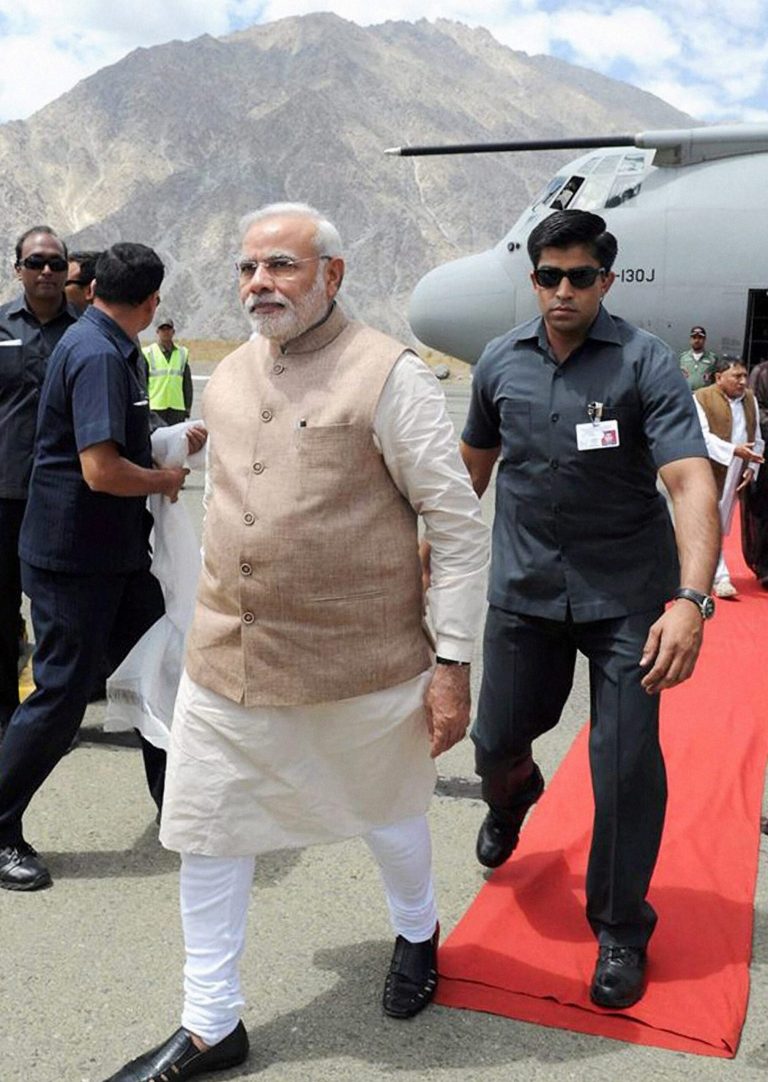 Indian Prime Minister Narendra Modi walks upon his arrival in Kargil, India, Tuesday, Aug. 12, 2014. Modi on Tuesday accused Pakistan of waging a proxy, terrorist war because it was too weak to fight a conventional one, a day after India accused its traditional rival of violating cease-fire agreements in the disputed Himalayan region of Kashmir. (AP Photo/Press Trust of India)