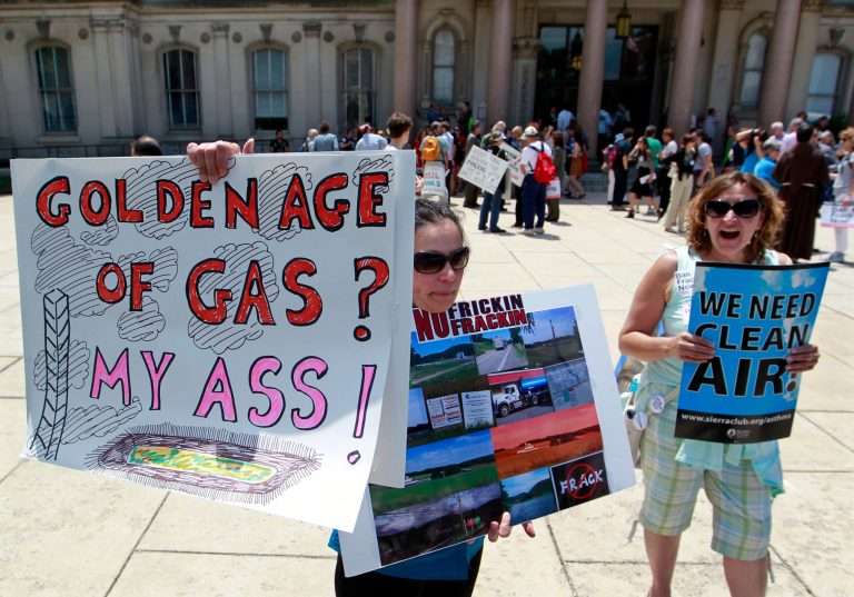   Environmental activists Janice Rapp, left, of Jackson, N.J., and Kathy Ottmer, of Ocean Gate, N.J., hold signs and shout at passing motorists outside the Statehouse in Trenton, N.J., Thursday, June 14, 2012, as they stand with a group hoping to keep wastewater from hydraulic fracturing in Pennsylvania from entering the Garden State. (AP Photo/Mel Evans)  