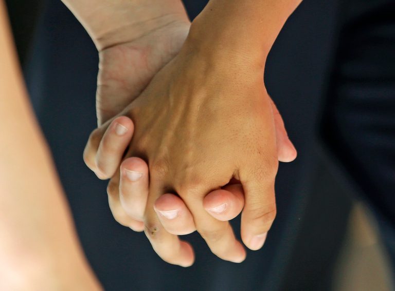 Angie and Kami Roe of West Jordan hold hands after leaving the federal courthouse Wednesday, July 15, 2015, in Salt Lake City. (AP Photo/Rick Bowmer)